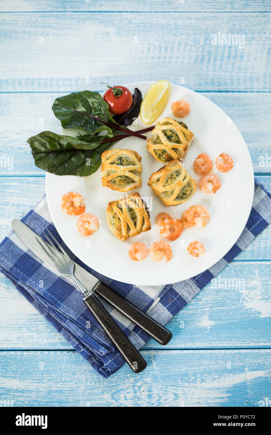 Blätterteigtaschen gefüllt mit Lachs & Spinat, Garnelen und Frischkäse, frischer Blattspinat Stock Photo