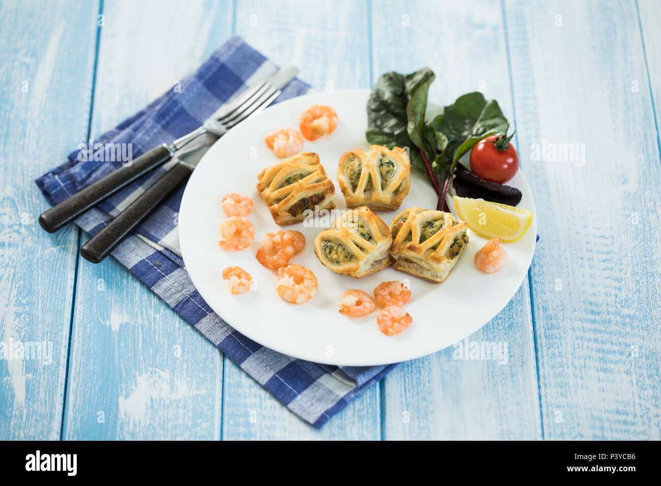 Blätterteigtaschen gefüllt mit Lachs & Spinat, Garnelen und Frischkäse, frischer Blattspinat Stock Photo