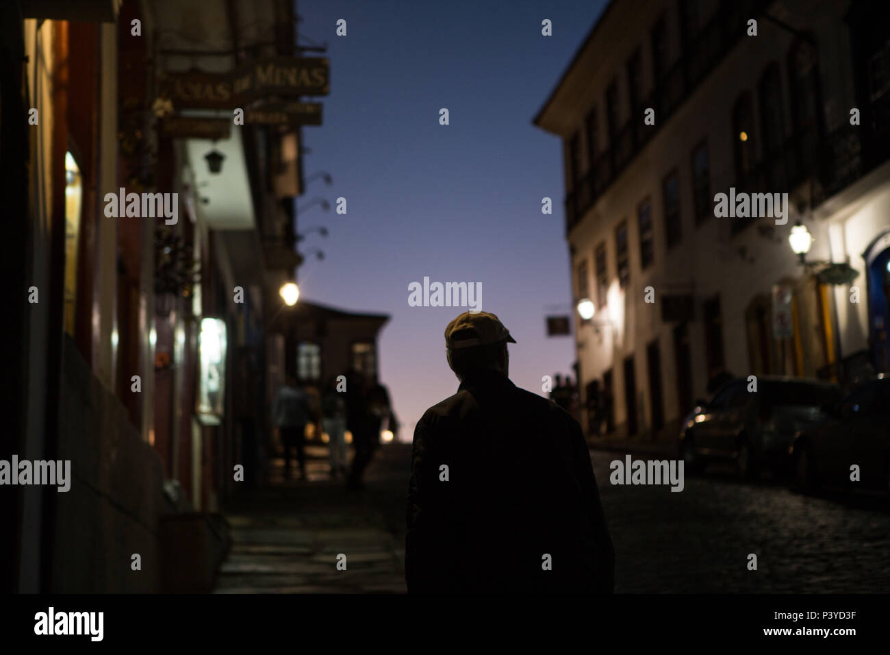 Um homem é visto caminhando  a noite nas ruas históricas da cidade de Ouro Preto, Minas Gerais. Stock Photo