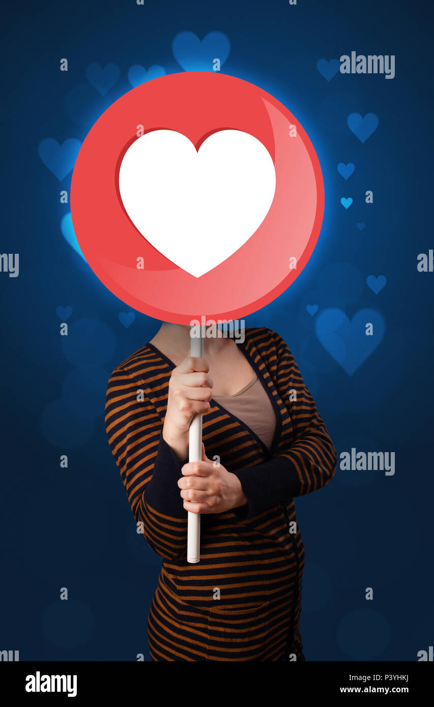 Casual young woman holding round sign with heart Stock Photo Alamy