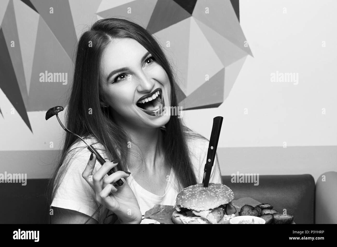 Laughing woman eating burger Stock Photo
