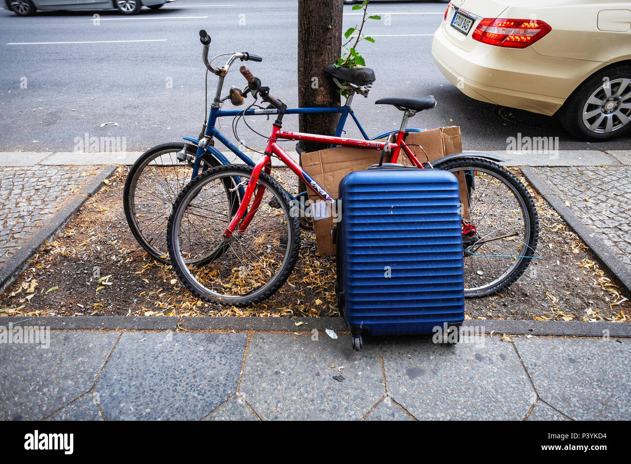 Possessions of the well equipped tourist - Bicycle, wheeled suitcase and spare wire coat hanger, Mitte,Berlin Stock Photo