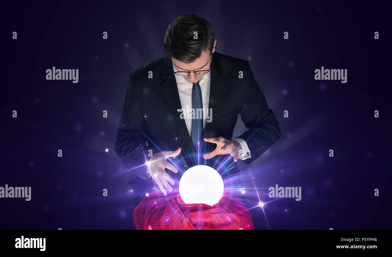 Young businessman sitting with crystal ball in action Stock Photo - Alamy