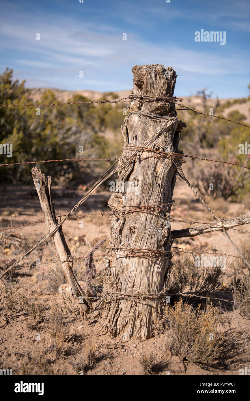 Rustic wood fencepost and rusted barbed wire at a New Mexico ranch Stock Photo