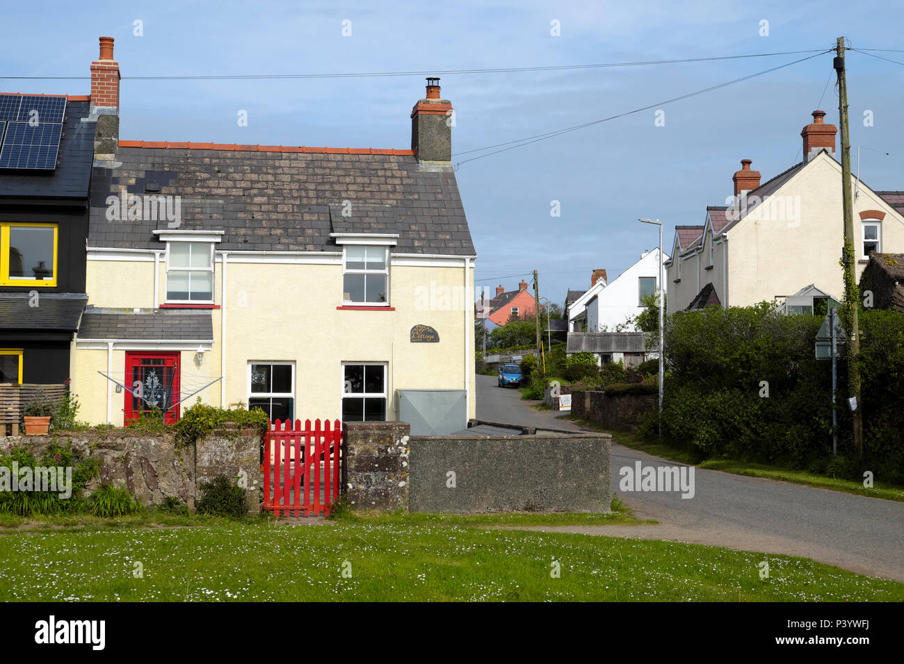 House cottage with red gate and red door in the village of Marloes in