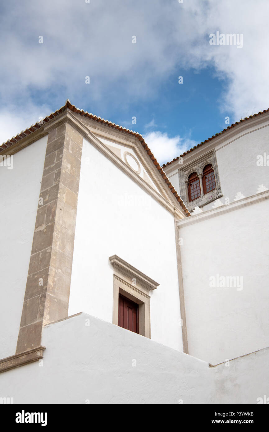 White buildings and walls of the Palace of Sintra underneath dramatic blue sky and clouds in Portugal Stock Photo