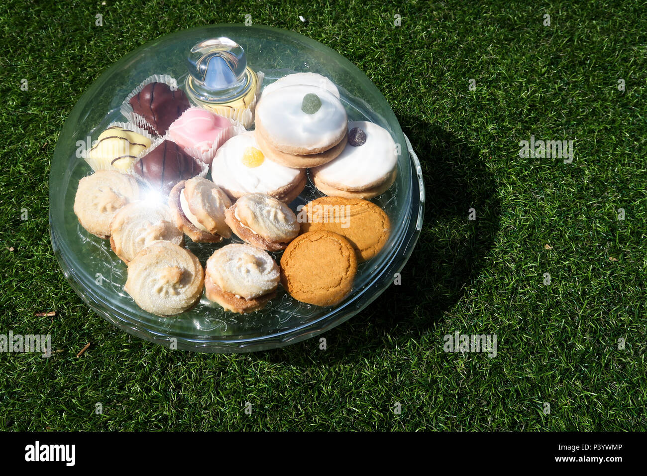 Selection of cakes under glass dome Stock Photo
