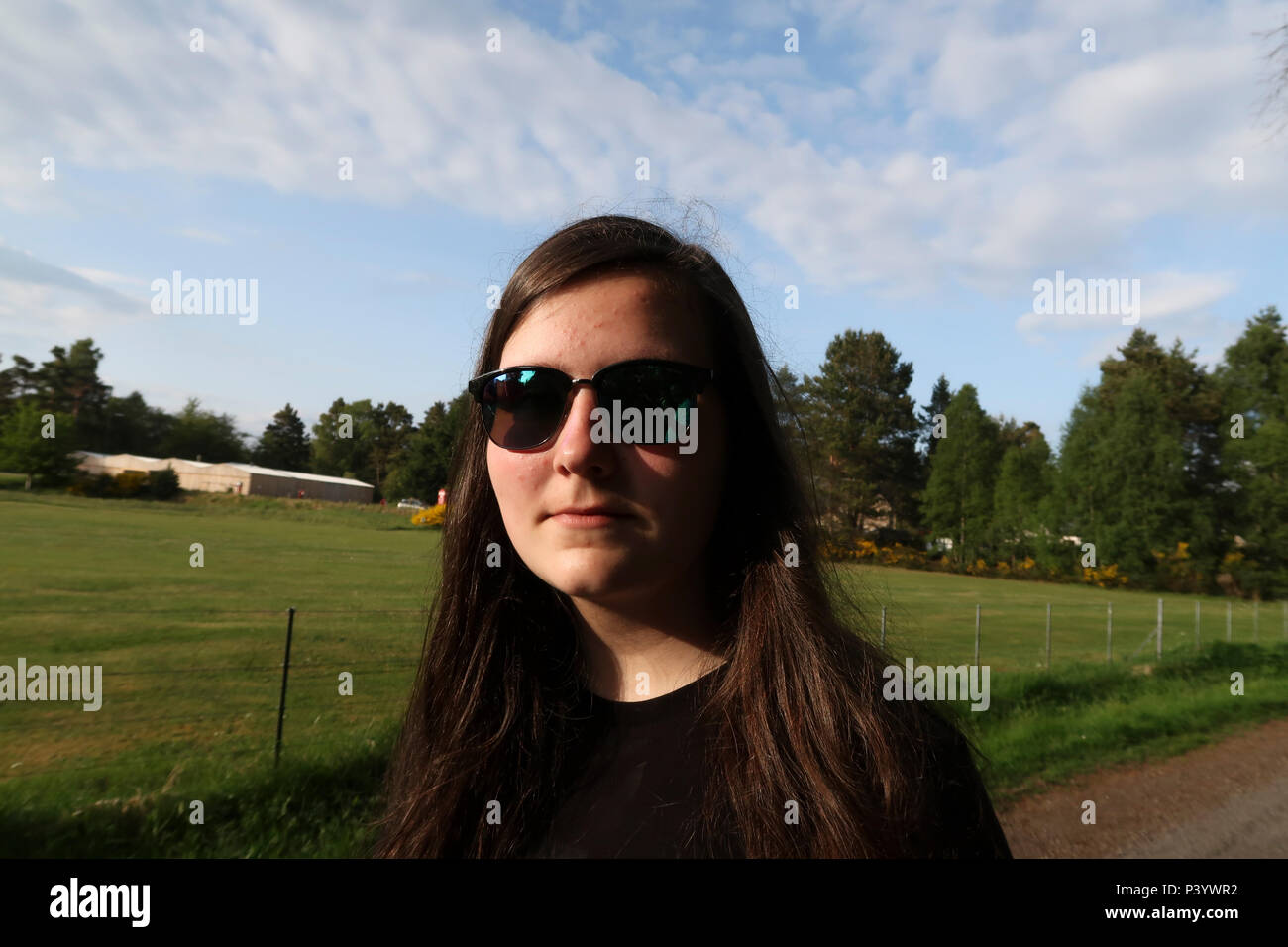 Portrait of bemused teenage girl with sunglasses Stock Photo