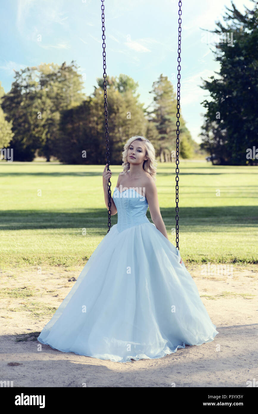 blonde woman in blue dress playing on swing Stock Photo - Alamy