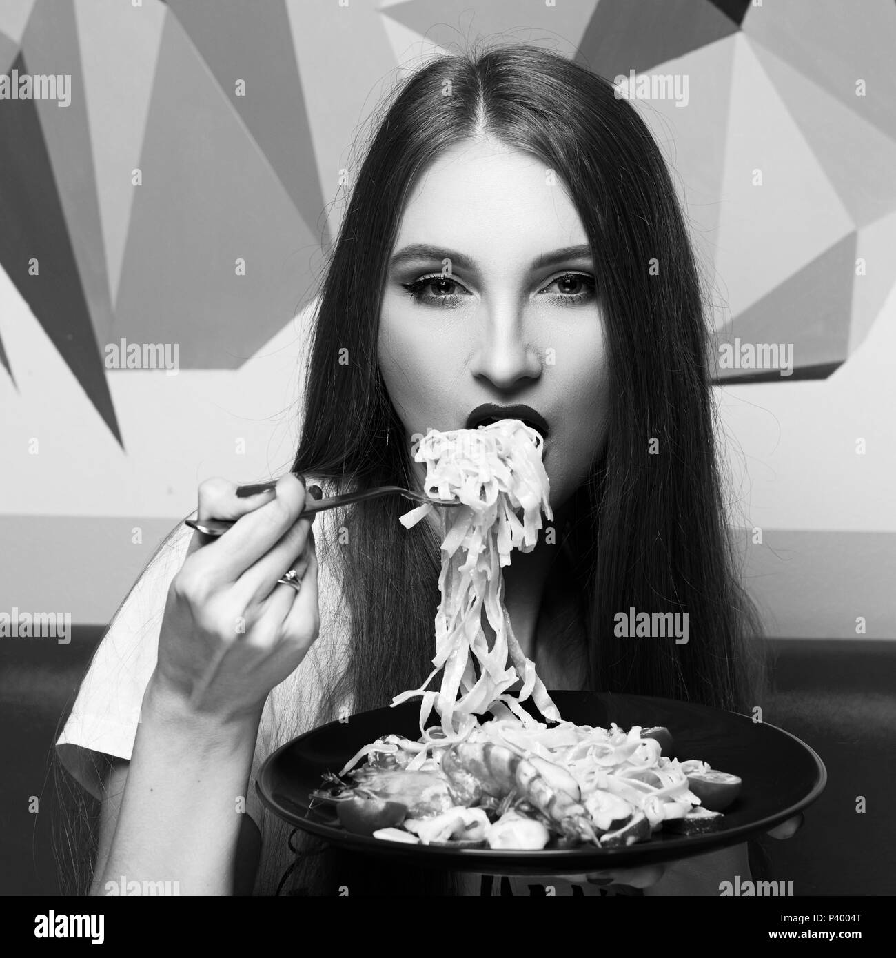 Attractive woman eating seafood pasta Stock Photo