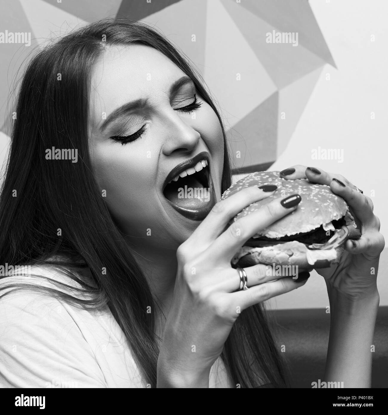 Portrait of beautiful woman eating burger Stock Photo