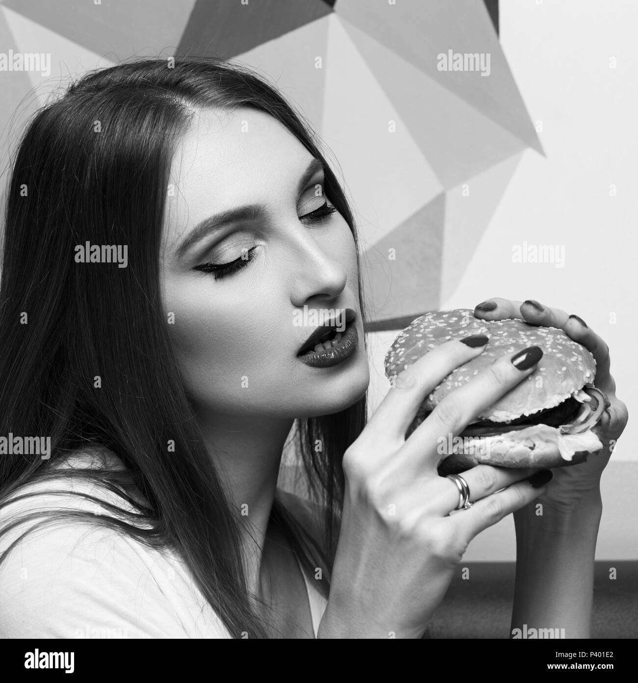 Portrait of beautiful woman eating burger Stock Photo
