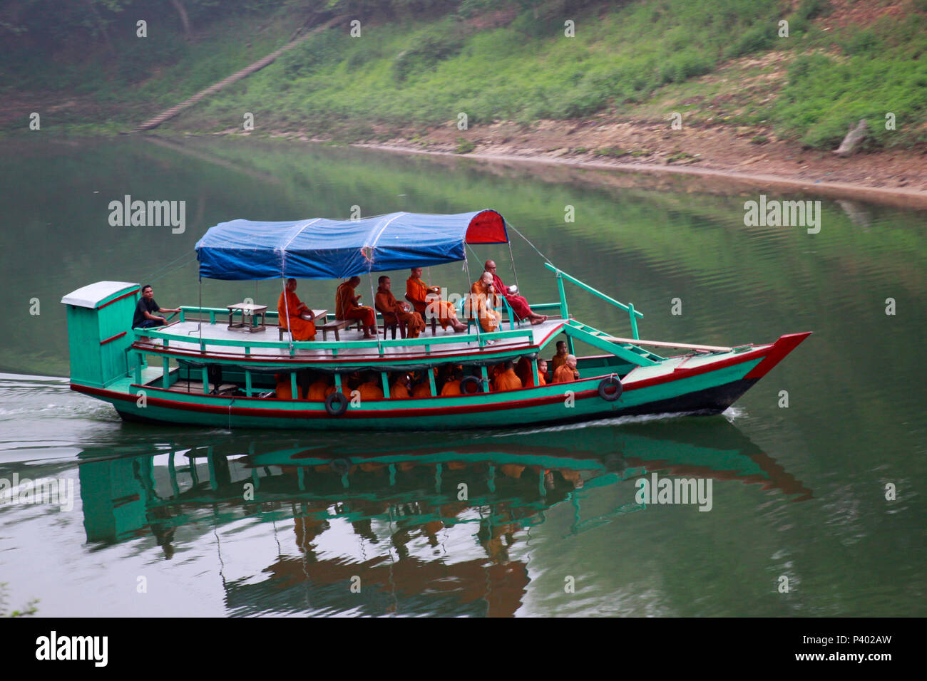 Buddhist monks travel on a boat in Kaptai lake in Rangamati, Bangladesh ...