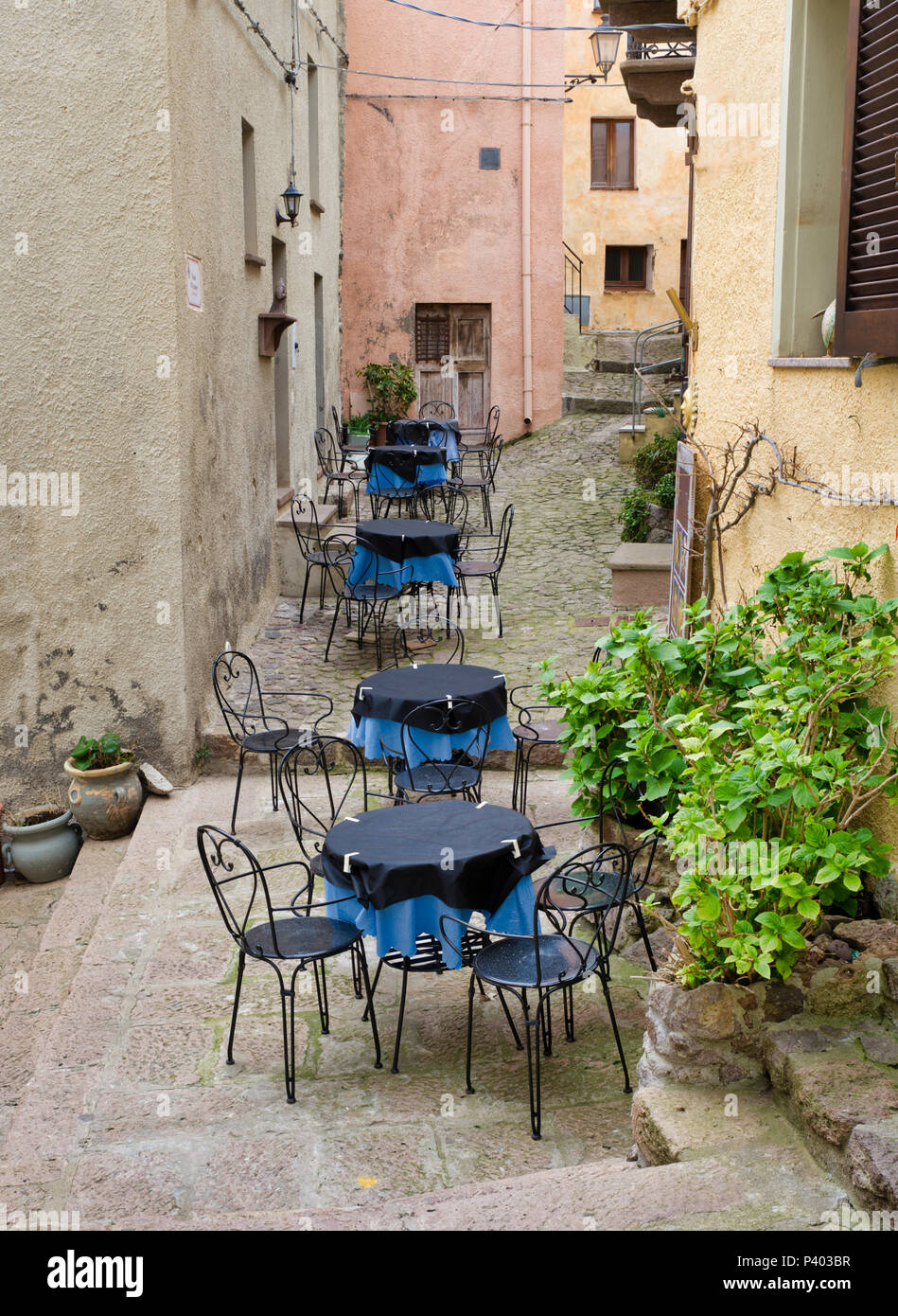 tables with blue cloth and chairs on an outdoor terrace in a street in castelsardo on sardinia Stock Photo