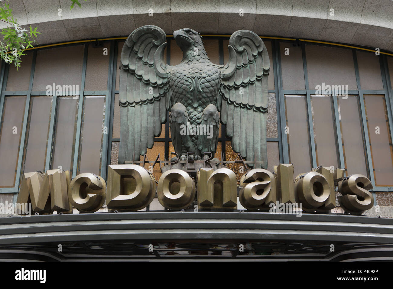 Bronze eagle over the McDonald's restaurant sign on the building of the former Imperial Café in Porto, Portugal. The emblematic historic building from the 1930s in the Praça da Liberdade is now known as the most beautiful McDonald's restaurant in the world. Stock Photo