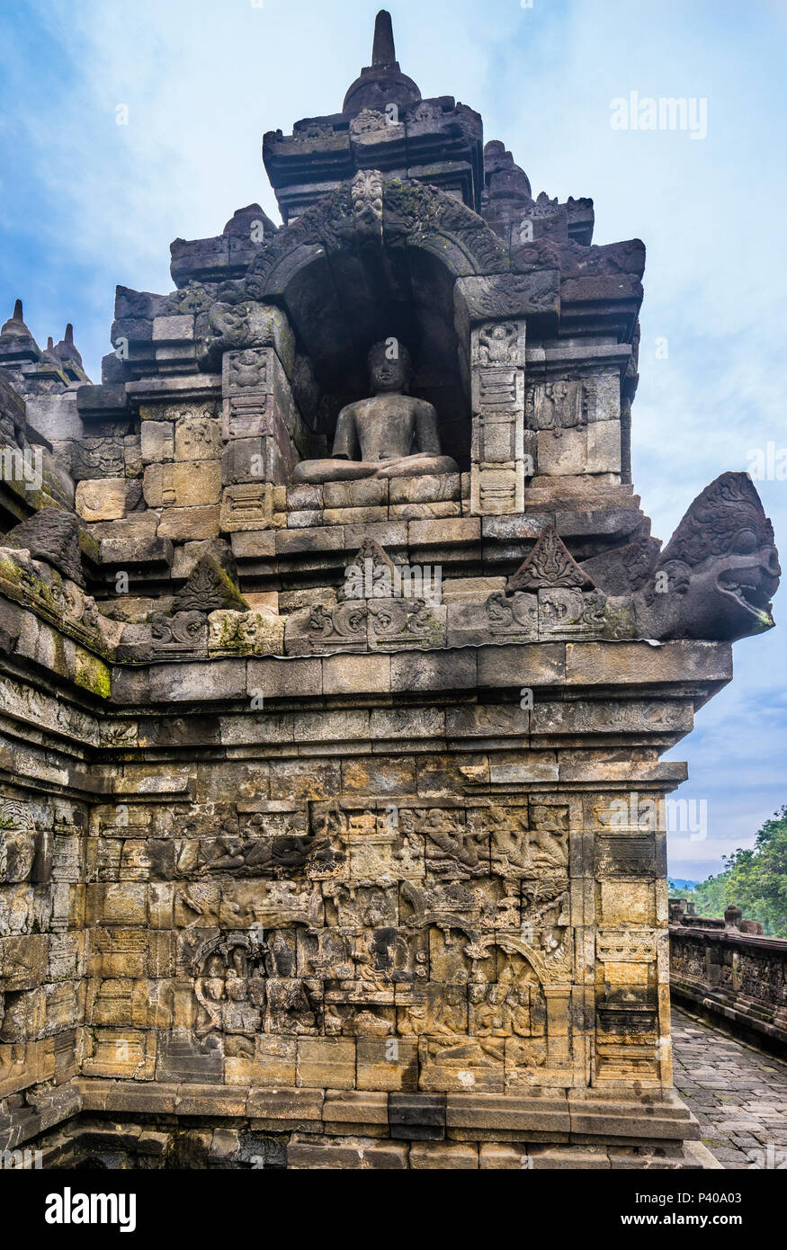 sitting Buddha statue in a niche above bas-reliefs at 9th century Borobudur Buddhist temple, Central Java, Indonesia Stock Photo