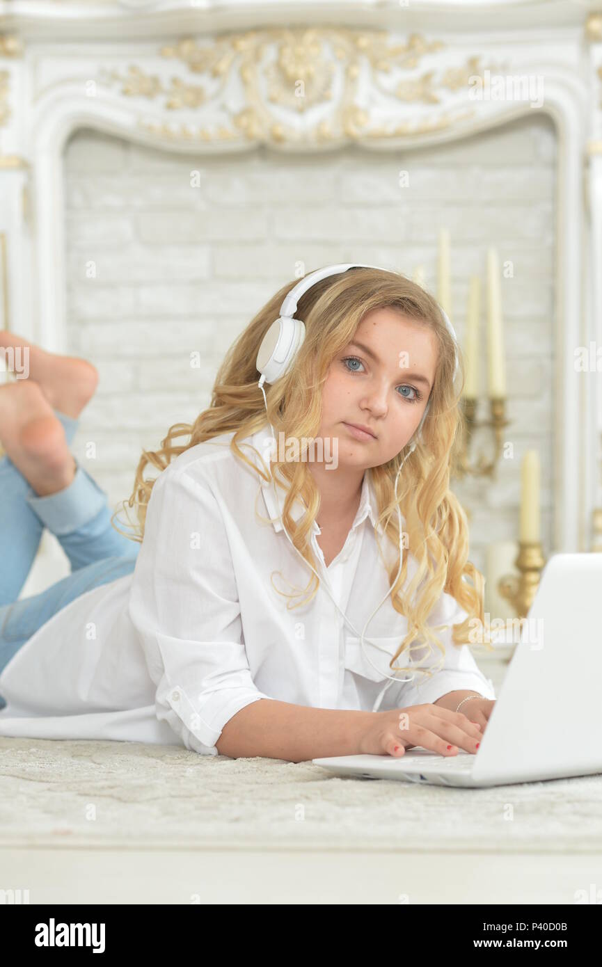 teenage girl in headphones lying on floor Stock Photo - Alamy