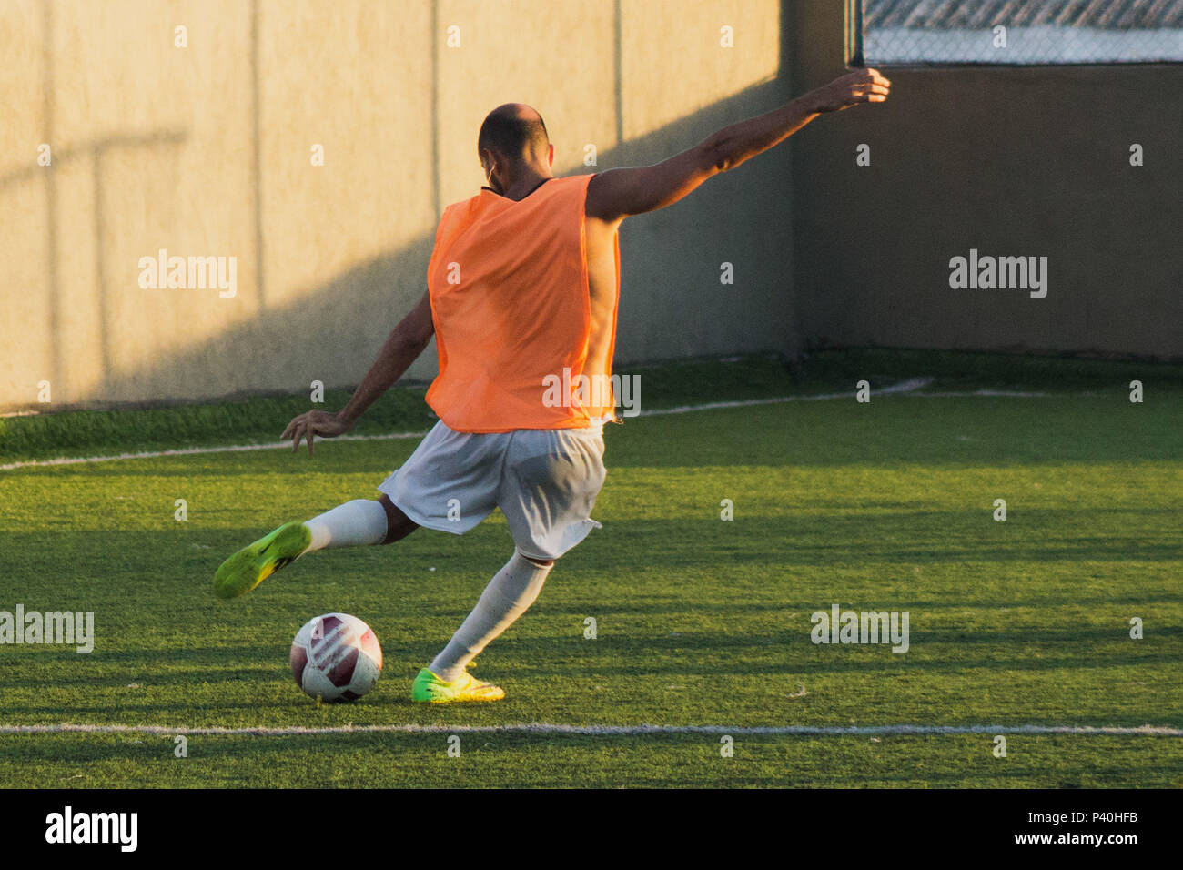 Jogador amador de futebol chuta uma bola Stock Photo - Alamy