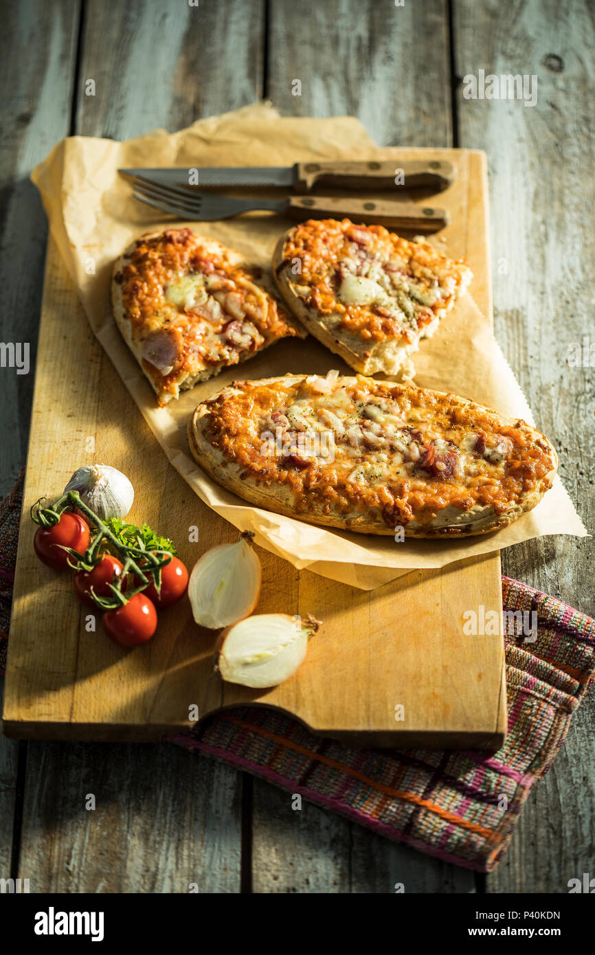 rustikales Pizzabrot mit Salami, Käse, Zwiebeln und Tomate Stock Photo