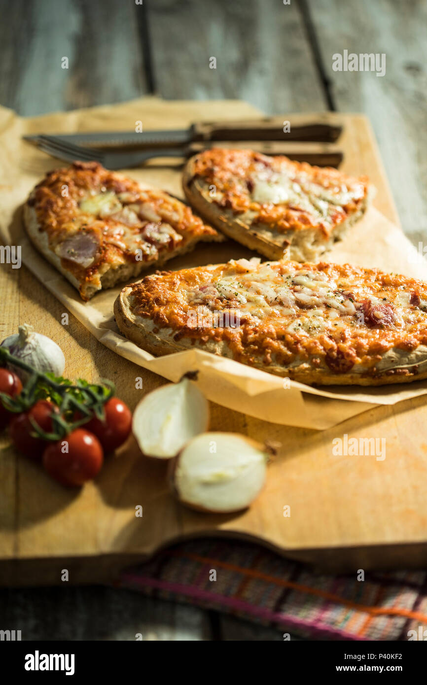 rustikales Pizzabrot mit Salami, Käse, Zwiebeln und Tomate Stock Photo
