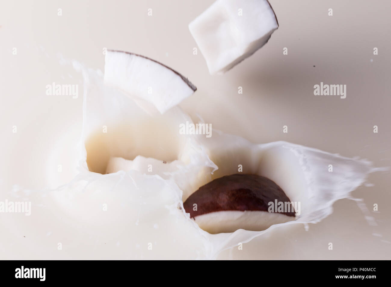 Coconuts splashing into coconut milk Stock Photo