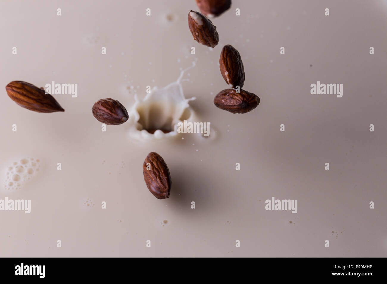 Almonds splashing into almond milk Stock Photo