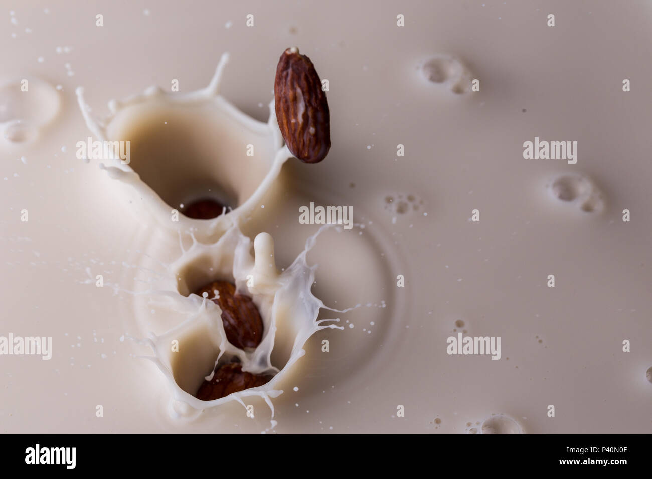 Almonds splashing into almond milk Stock Photo