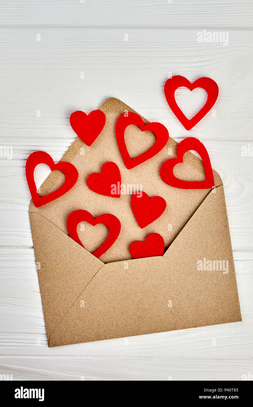 Opened envelope and red paper hearts. Envelope from craft paper and many red hearts. Love letter concept. Stock Photo