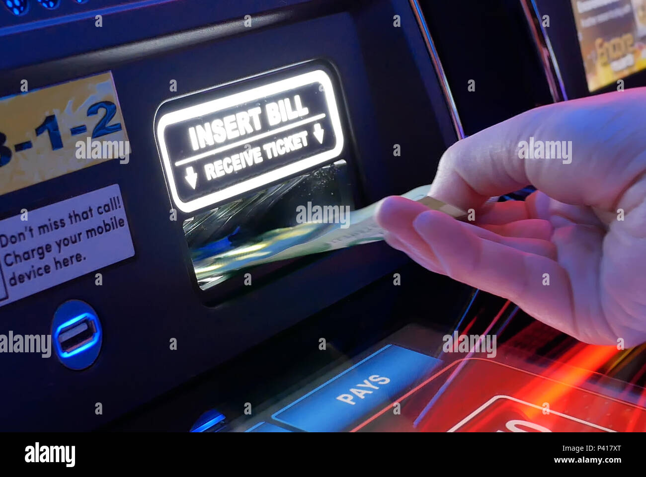 Coquitlam, BC, Canada - June 12, 2018 : Motion of woman inserts money on slot machine inside Casino Stock Photo