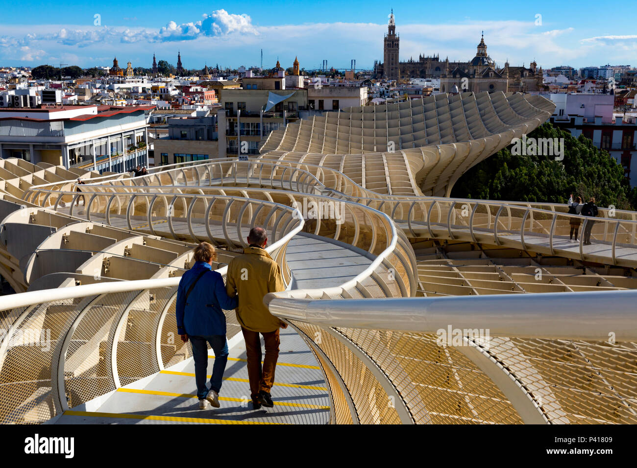 Couple walking The Metropol Parasol overhead walkway, Plaza De La Encarnacion, Seville, Andalusia, Spain. Stock Photo
