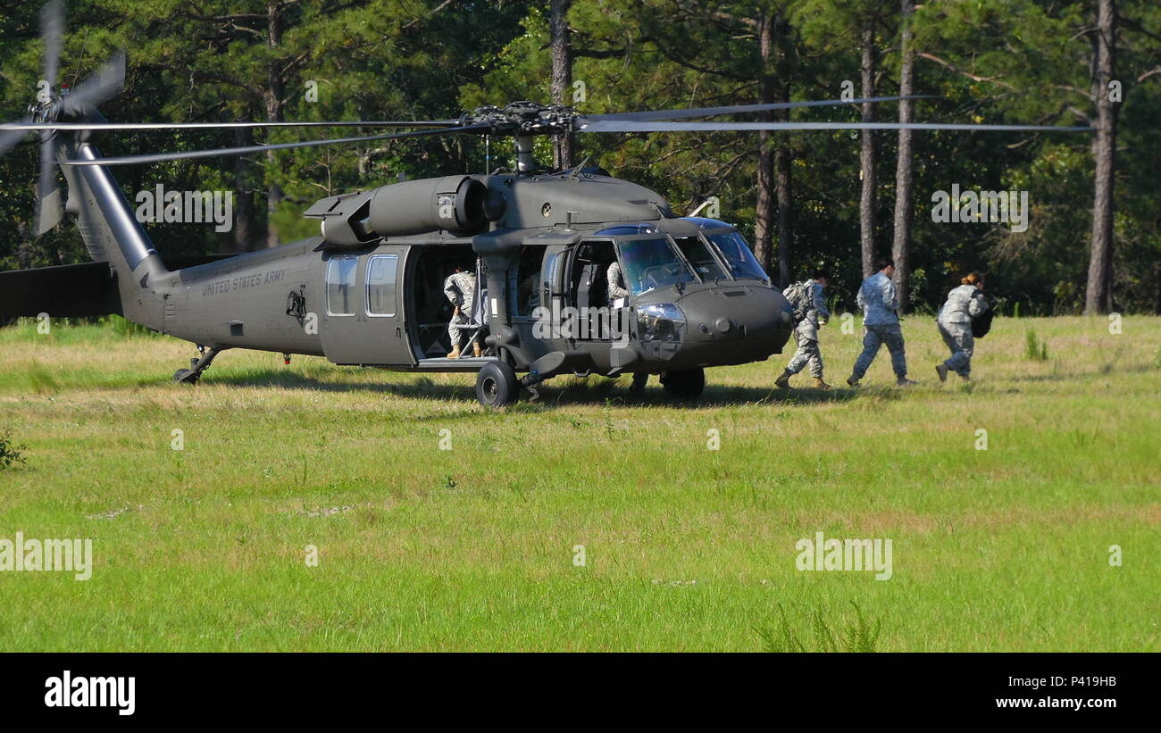 Soldiers assigned to the U.S. Army Reserve Command Augmentation Unit (UAU) arrive at a landing zone aboard Army Reserve UH-60 Black Hawk helicopters assigned to A Company 1st Battalion, 169th Aviation Regiment to perform a land navigation and orienteering exercise during their Battle Assembly on June 4, 2016, at Fort Bragg, N.C. The training required soldiers to navigate to fixed points using a compass, map and protractor.  The mission of the UAU is to augment United States Army Reserve Command staff during exercises, crisis actions, or a presidential selective reserve call-up. Soldiers of the Stock Photo