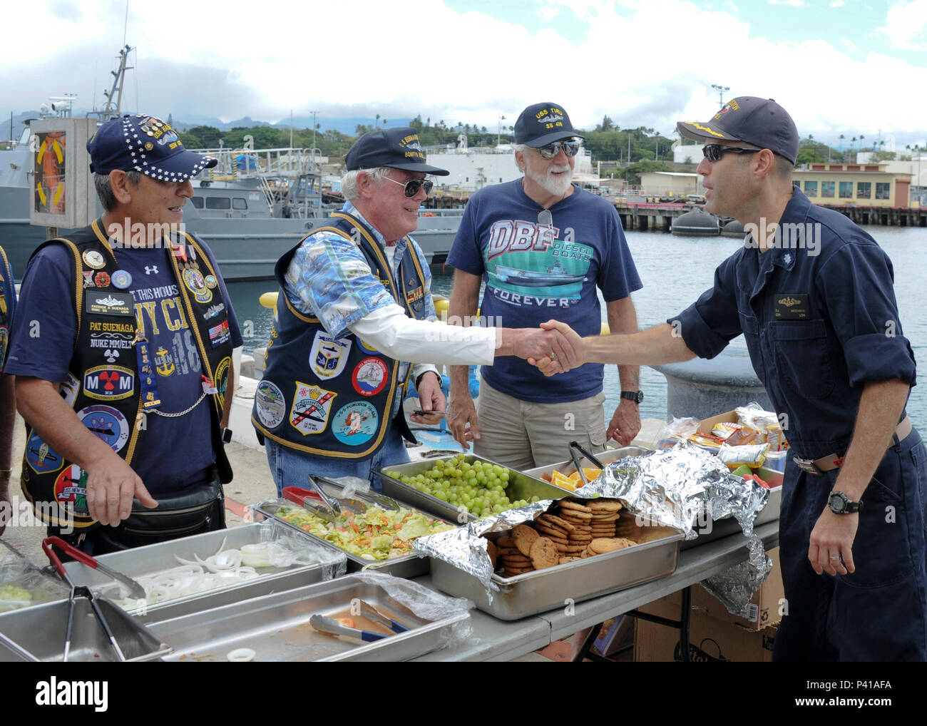 160606-N-KV911-058  PEARL HARBOR (June 6, 2016) Tim Seipp, a member of the Submarine Veterans Bowfin Base, bids Cmdr. Scott McGinnis, commanding officer of the Los Angeles-class fast-attack submarine USS Houston (SSN 713), farewell. Houston is en route to Puget Sound Naval Shipyard in Bremerton, Washington, to commence its inactivation process and decommissioning after 33 years of service. (U.S. Navy photo by Mass Communication Specialist 2nd Class Shaun Griffin/Released) Stock Photo