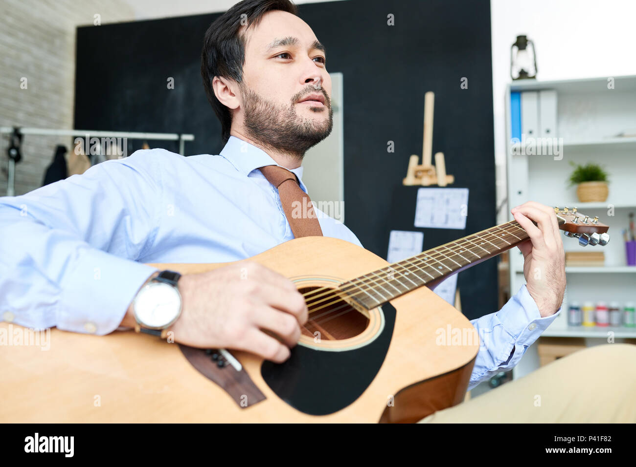 Handsome man with guitar in studio Stock Photo