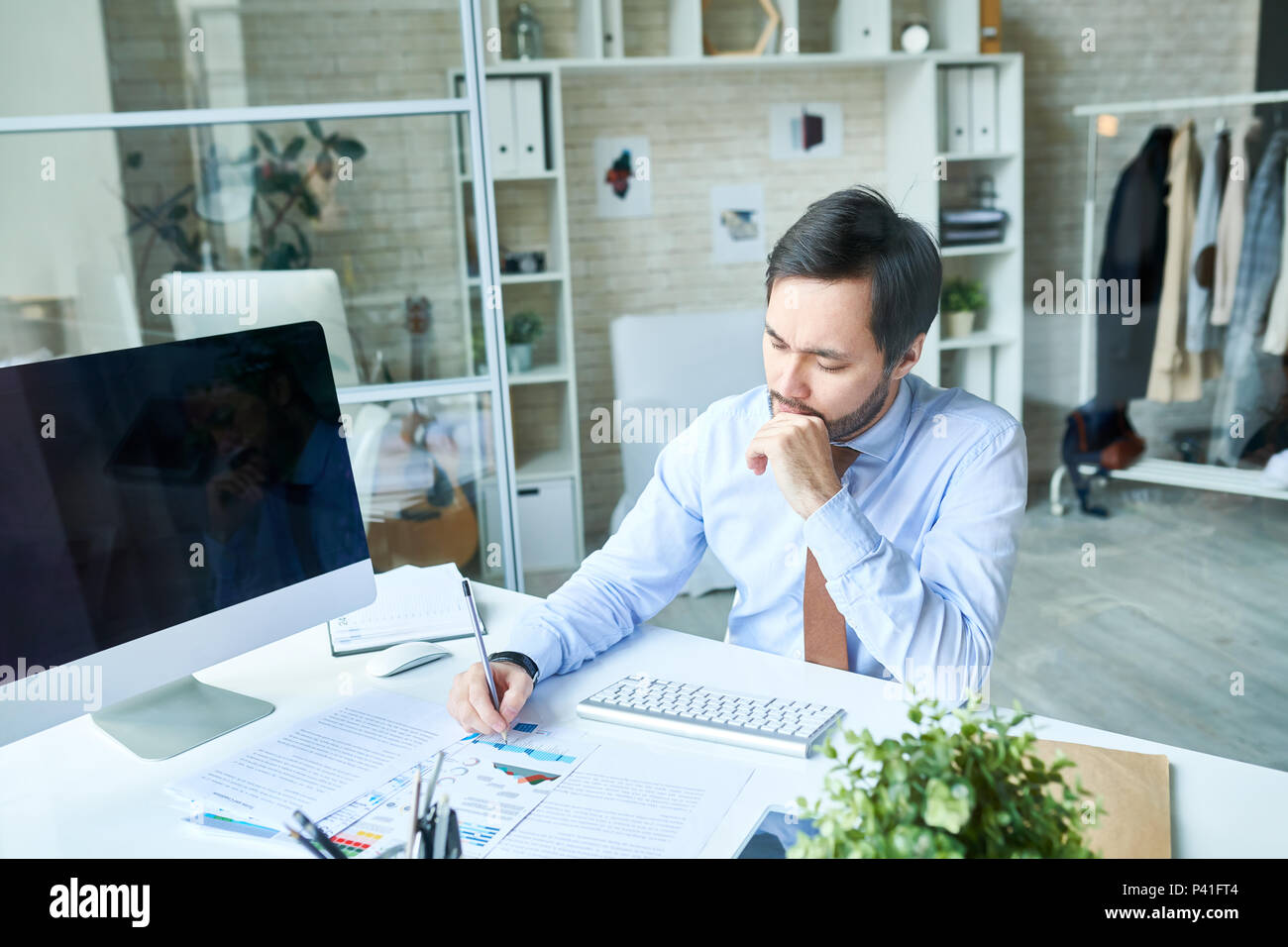 Thoughtful man working in office Stock Photo
