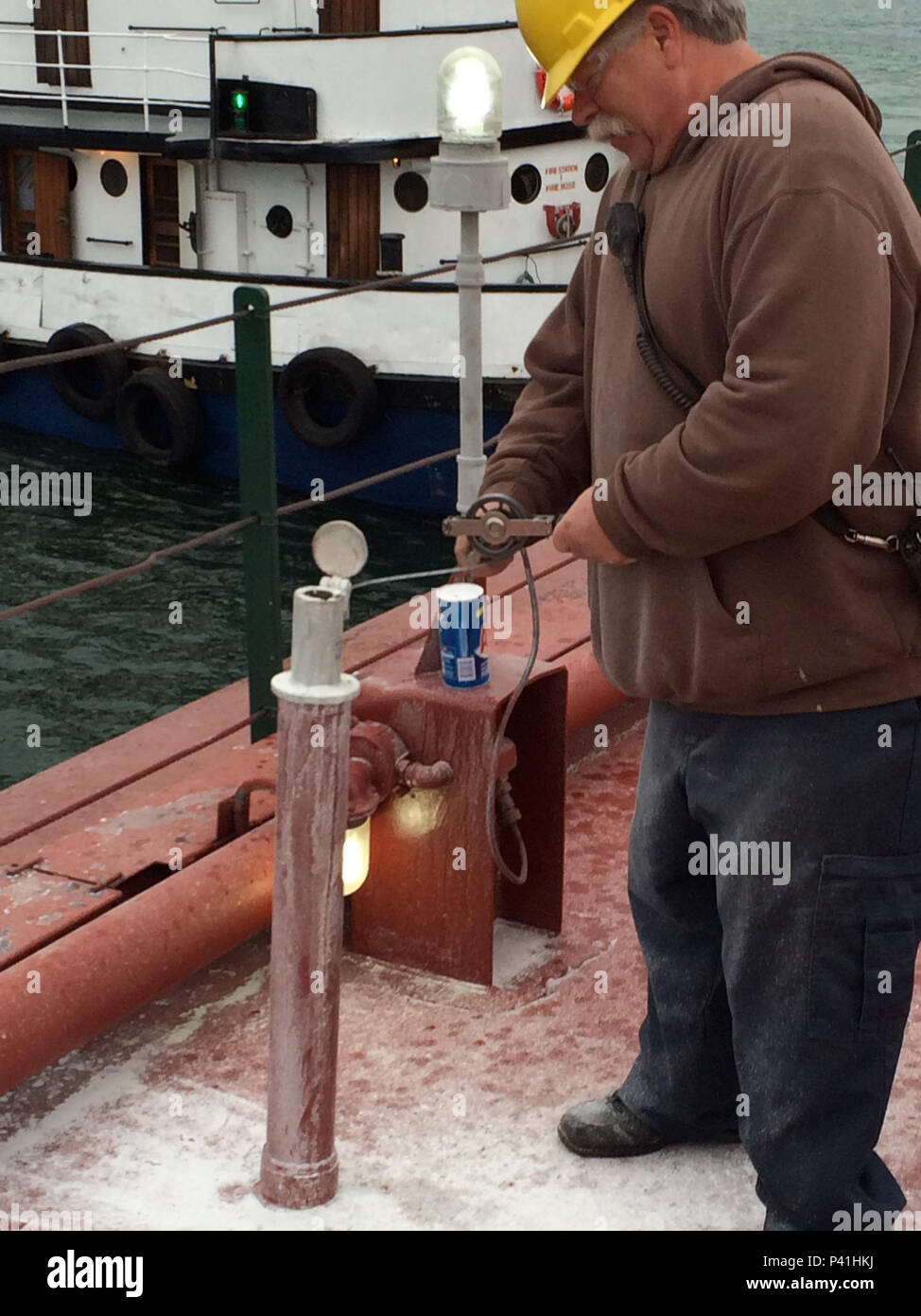 George Fill, a deck hand aboard the motor vessel Roger Blough, measures the amount of water in a ballast tank aboard the motor vessel in Lake Superior, June 4, 2016.     The Blough ran around near the Gros Cap Reef Light more than one week ago.    U.S. Coast Guard photo by Craig Gorman Stock Photo