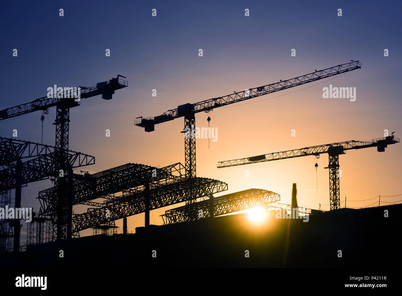 construction crane over tower building site silhouette sunrise ...