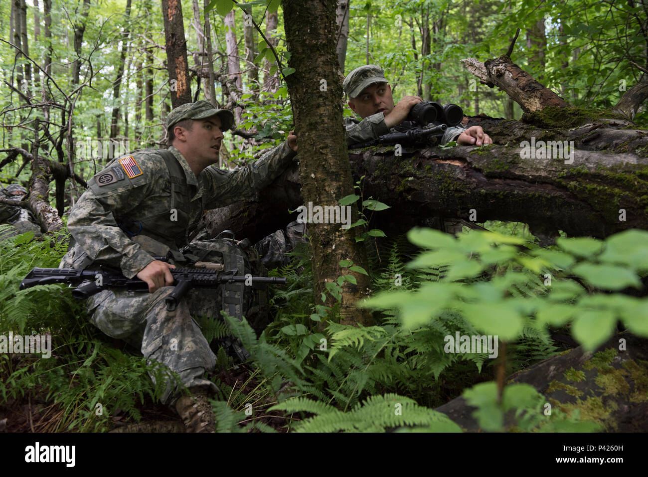 U.S. Army Staff Sgt. Logan Blacklock (left) and Sgt. Graham Skinner, both scouts assigned to Headquarters, Headquarters Company, 3rd Battalion, 172nd Infantry Regiment (Mountain), Vermont National Guard, communicate while monitoring opposition forces during a reconnaissance training mission on Camp Ethan Allen Training Site, Jericho, Vt., June 6, 2016. Multiple companies from the 86th Infantry Brigade Combat Team are participating in multiple training events over the course of the next two weeks as part of their annual training. (U.S. Air National Guard photo by Tech. Sgt. Sarah Mattison/Relea Stock Photo