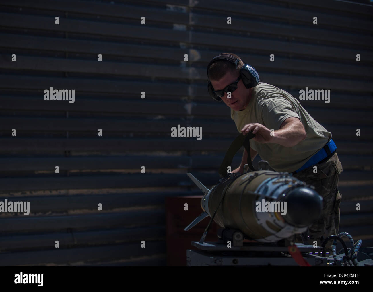 Technical Sgt. Joseph McCullough, 455th Expeditionary Aircraft Maintenance Squadron weapons maintainer, straps down a GBU (Guided Bomb Unit)-54 to a munitions loader at Bagram Airfield, Afghanistan, June 07, 2016. The 455th EAMXS weapons flight load F-16s with both offensive and defensive explosive devices to support various air tasking orders. (U.S. Air Force photo by Senior Airman Justyn M. Freeman) Stock Photo