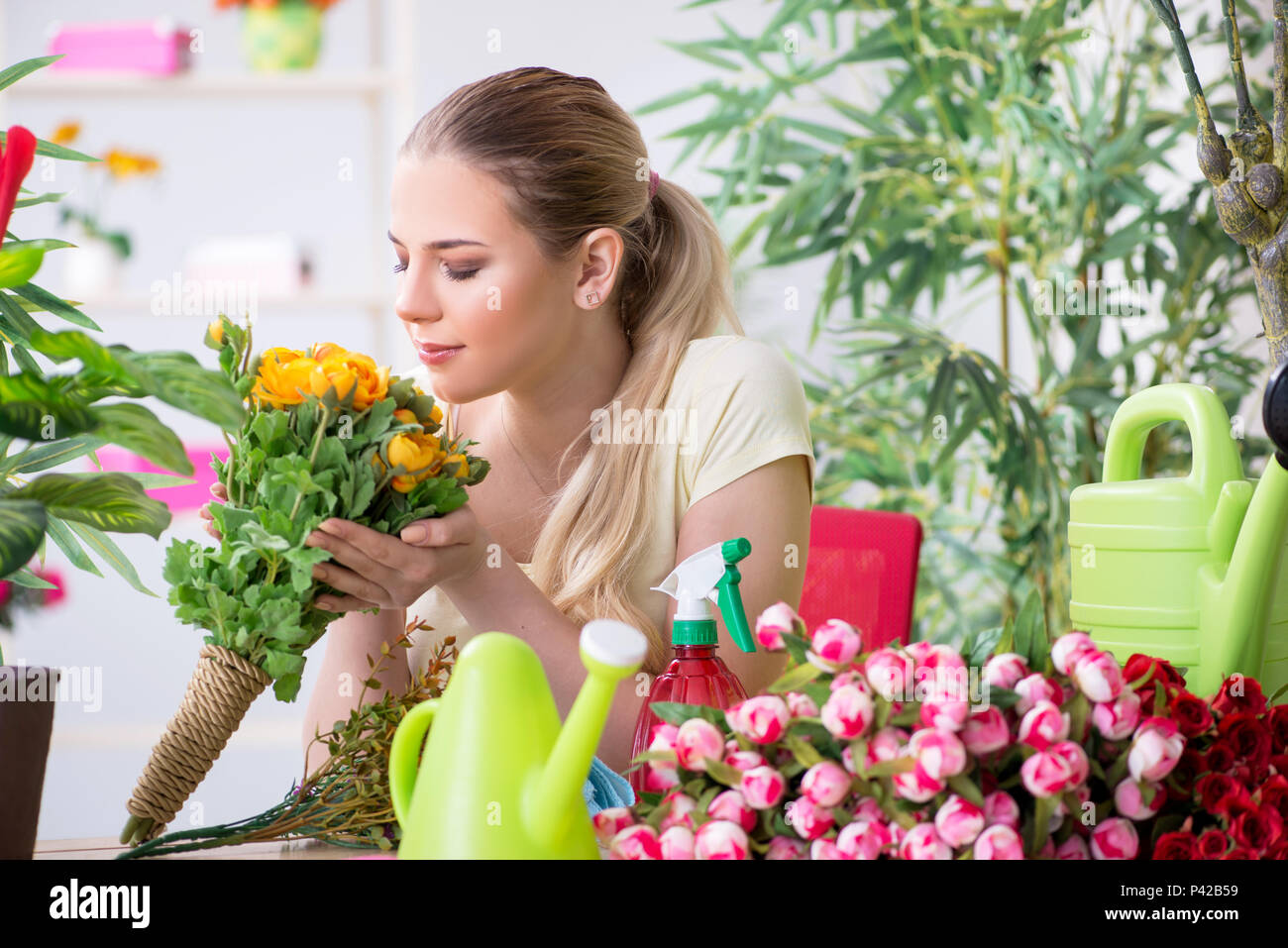 Young woman watering plants in her garden Stock Photo - Alamy