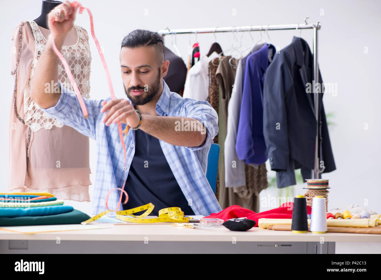 Male tailor working in the workshop on new designs Stock Photo - Alamy