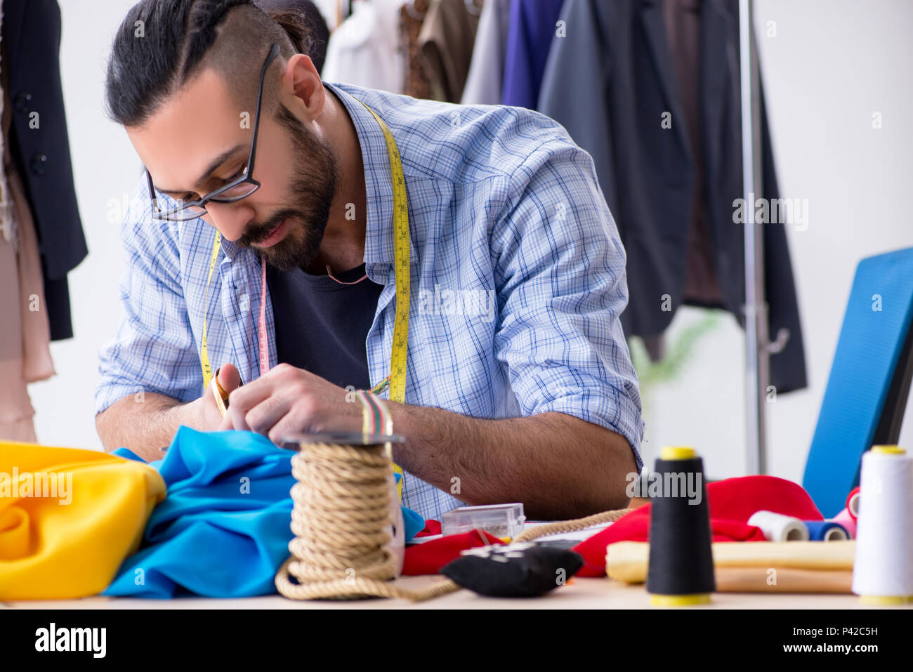 Male tailor working in the workshop on new designs Stock Photo - Alamy