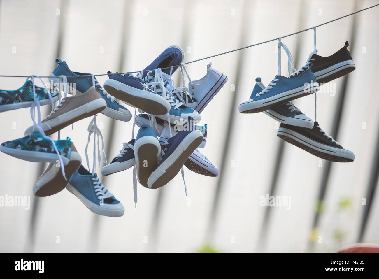 Pairs of sneakers and shoes hanging on a rope Stock Photo Alamy