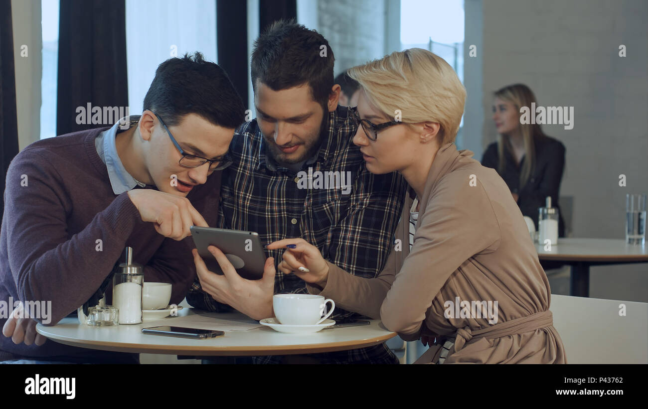 Creative team using smartphone and talking in casual office Stock Photo