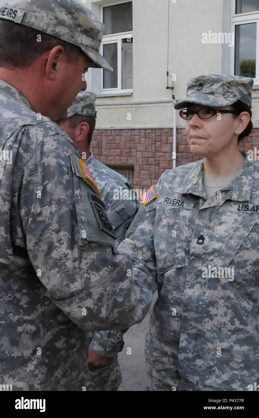 Sgt. 1st Class Rivera, with the 382nd Combat Sustainment Support Battalion, is presented with a commander's coin from Command Sgt. Maj. Thomas P. Brashears, the command sergeant major with the 364th Expeditionary Sustainment Command, for her exceptional contribution to Anakonda 2016 in Warsaw, Poland, June 6, 2016. Anakonda 2016 is one of U.S. Army Europe's premier multinational training events, which features 24 nations and seeks to train, exercise and integrate Polish national command and force structures into an allied, joint, multinational environment. Stock Photo