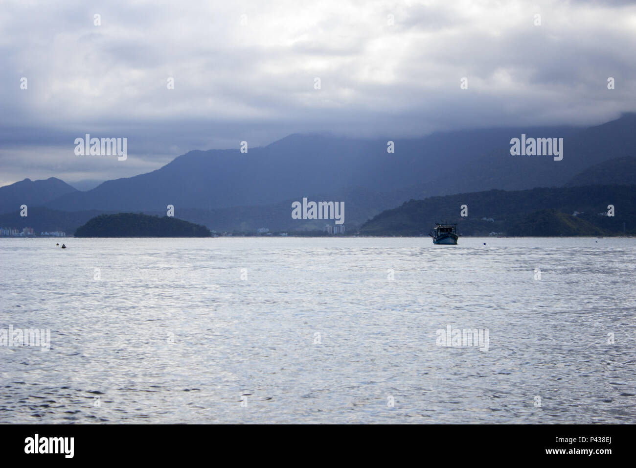 Costa De Ilha Com Barco Navegando No Mar Com Montanhas Ao Fundo Em Ubatuba Sp Brasil Stock Photo Alamy