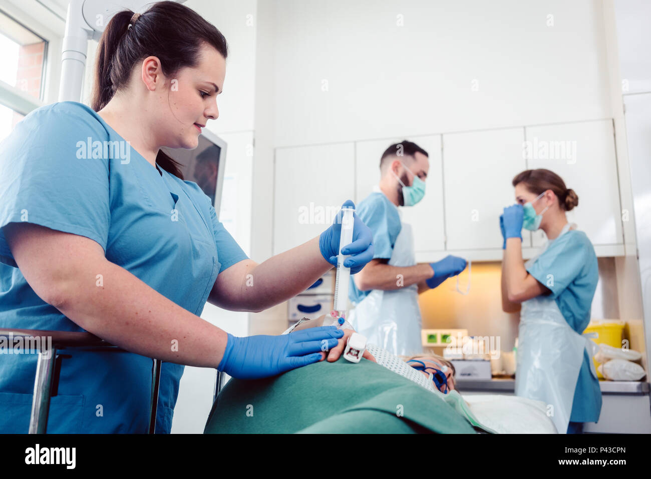 Nurse giving anesthesia to patient waiting for endoscopy Stock Photo