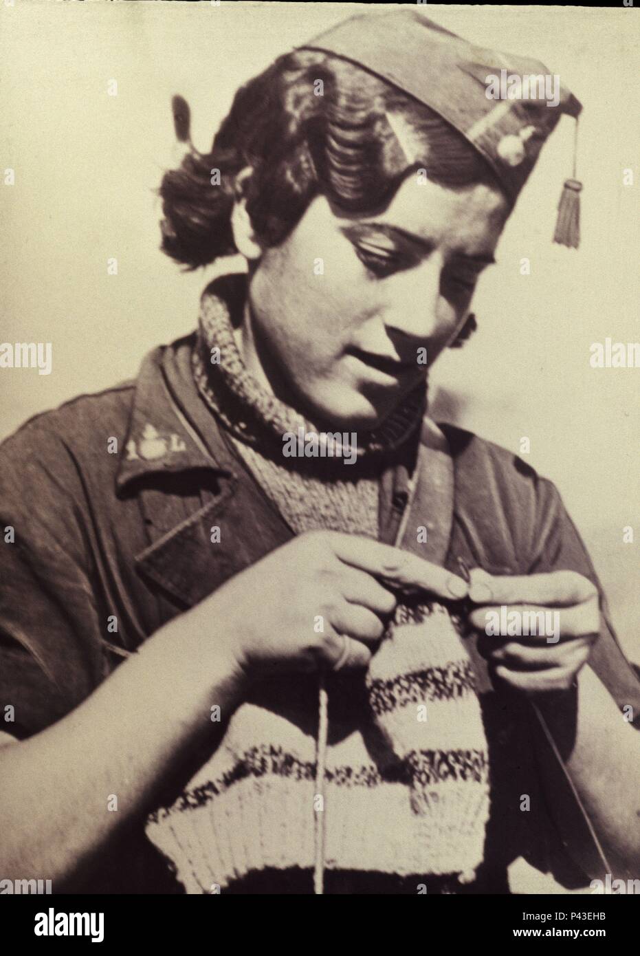 FOTOGRAFIA-MUCHACHA CON UNIFORME MILITAR HACIENDO PUNTO. Location:  EXPOSICION DE LA GUERRA CIVIL ESPAÑOLA, MADRID Stock Photo - Alamy