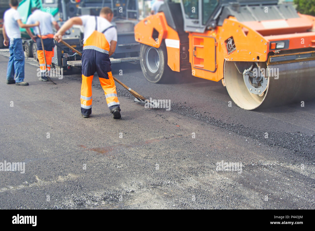 Construction workers on asphalting and road repair Stock Photo