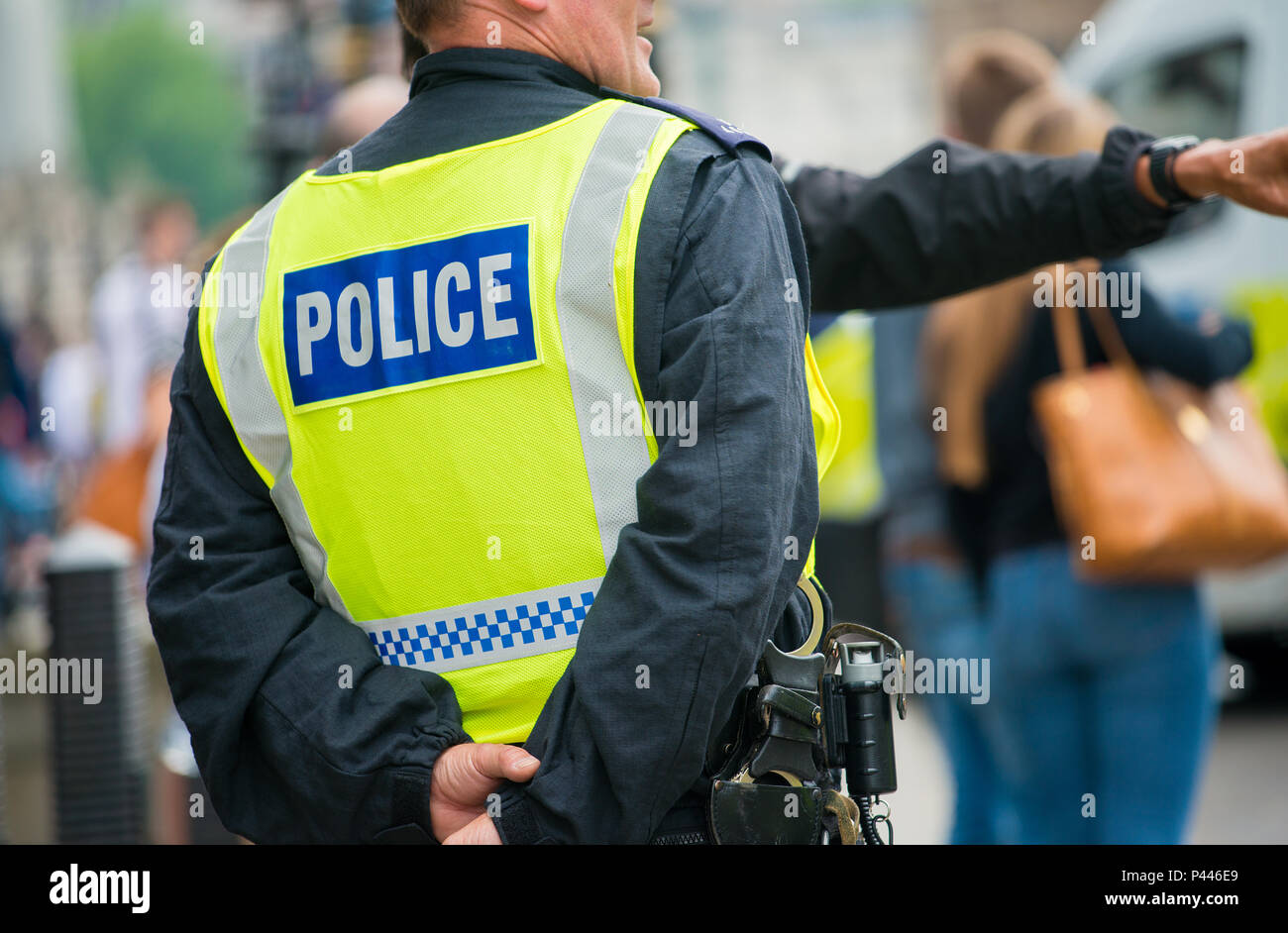 Metropolitan police officer wearing high visibility vest with POLICE printed on the back, while on duty in London, UK. Stock Photo