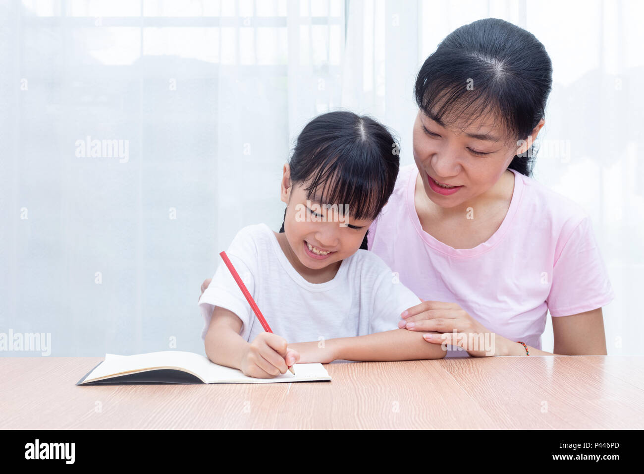 Asian Chinese mother teaching daughter doing homework at home Stock ...